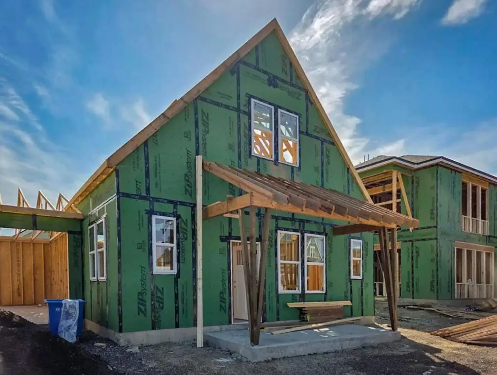 One newly framed single-family home with a roof overhang.
