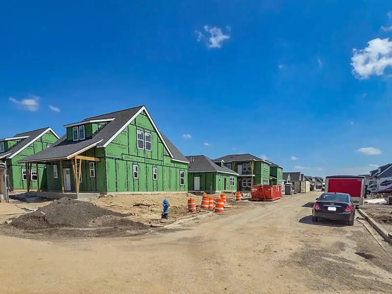 Newly framed ranch style single family homes in a housing development.